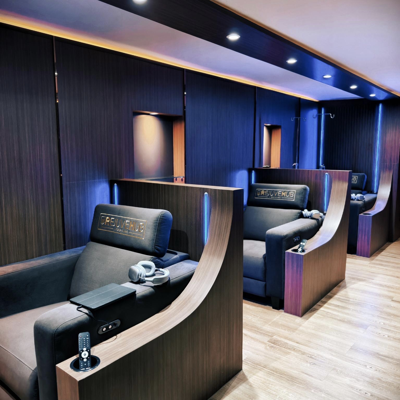 RejuveHub private lounge — recliner pods with embroidered headrests